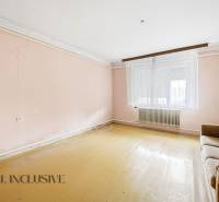 Living room with simple furniture and light pink walls in a family house.