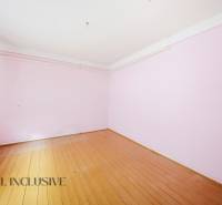 A room with pink walls and a wooden decor floor in a family house.