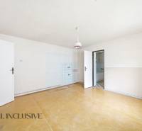 A spacious room in a family house with a wooden decor floor and simple lighting.