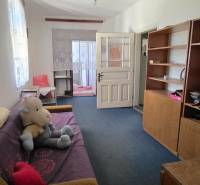 A living room of a family house with a sofa, a shelving unit, and a toy on the floor.