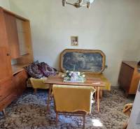 The family house includes a dining room with a carpeted floor, furniture, and a hanging chandelier.