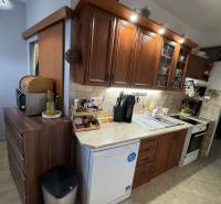 A kitchen in a 3-room apartment with wooden cabinets and appliances, a floor with a wooden decor.