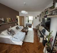 Living room with a sofa, table, and wooden decor flooring in a 3-room apartment.