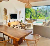 A family house with a wooden decor floor, wicker lamps, and a view of nature.