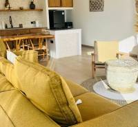 The interior of a family house with a sofa, kitchen, rattan chairs, and accessories made from natural materials.