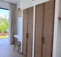 Interior of a family house with a wooden decor floor and rattan elements.