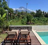 A swimming pool at a family house in Amed with a view of the mountains and greenery.