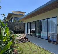 The garden of a family house in Amede with glass and loungers on the terrace.
