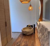 Interior of a family house with a stone sink, wooden countertop, and hanging lamps.