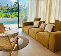 Living room of a family house with a large window, view of the garden and pool.