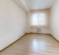 A bright room with a window and a wooden decor floor in a 2-room apartment.