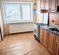 A kitchen in a family house with a wooden decor floor and a pendant light.