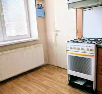 A kitchen in a family house with a gas stove and a wooden decor floor.