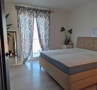 A bedroom with a large bed, plants, a mirror, and curtains in a 3-room apartment.