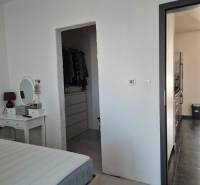 Bedroom with a mirror, entrance to the wardrobe, and hallway in a 3-room apartment.