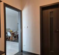 A hallway in a 3-room apartment with doors and a view into the dining room.