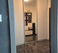 A hallway in a 3-room apartment with tiles and a built-in wardrobe.
