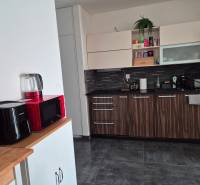 A kitchen in a 3-room apartment with modern appliances and decorative wood.