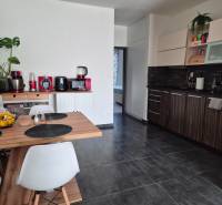 A kitchen in a 3-room apartment with a dark floor and wooden decor furniture.