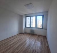 Office room with wood-patterned flooring and a large window on Tulská Street in Zvolen.