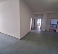 Open office space with white walls and linoleum flooring.