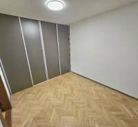 A room in a 2-room apartment with a wooden decor floor and storage space.
