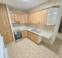 A kitchen with a kitchen unit in a new 2-room apartment, tiles and beige tiling.