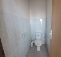 A restroom in a building with ceramic tiles and flooring.