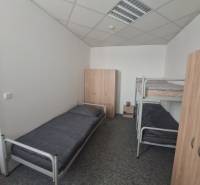 The interior of a building with beds and wardrobes, a floor with wooden decor.