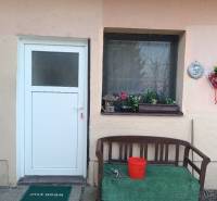 Entrance to a one-room apartment with a bench and floral decorations.