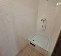 Shower corner with white tiles in commercial premises.