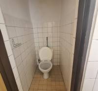 A restroom with white tiles in commercial premises.