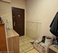 Entrance hall in a 3-room apartment with stone cladding and storage spaces.