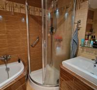 A bathroom in a 3-room apartment with a bathtub, shower, and sink.