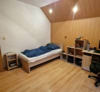 A room in a 3-room apartment with a bed, a desk, and a floor with a wooden decor.