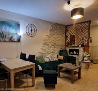 Living room with wood-patterned flooring and stylish seating in a three-room apartment.