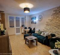 Living room in a 3-room apartment with a wooden decor floor and decorative elements.