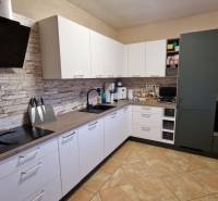 A kitchen in a 3-room apartment, light cabinets, stoneware tiles, kitchen appliances.
