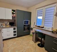 A kitchen in a 3-room apartment with a floor and kitchen cabinets with a wooden decor.