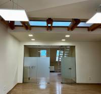 Interior of an office with wood-patterned flooring and glass doors.