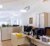 Offices with wood-patterned flooring, work desks, and storage cabinets.
