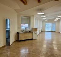Offices with wood-patterned flooring, large windows, and a kitchenette.