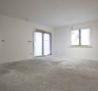 A room in a family house with unfinished floors and walls, without furnishings.