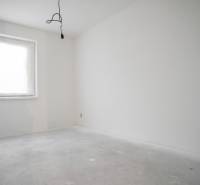 Empty room with white walls and a bright window in a family house.