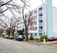 Pod Párovcami Street, Piešťany: A line of cars near a white building, not far from a 2-room apartment.