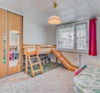 Children's room with a bunk bed, cabinets, and colorful chairs in a 4-room apartment.