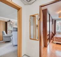 Interior of a 4-room apartment with wood-decor flooring, furniture, and a mirror.