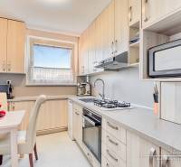 A kitchen in a 4-room apartment with fruit on the table and built-in appliances.