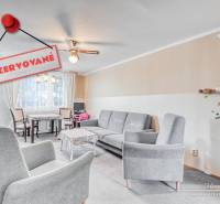 Living room in a 4-room apartment with comfortable armchairs and a dining area.