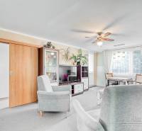 A bright living room with sofas in a 4-room apartment and a floor with a wooden decor.